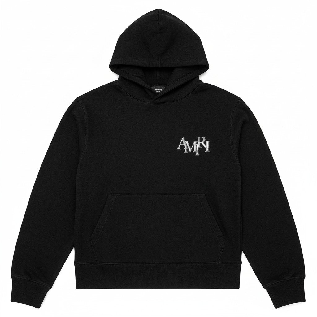Sudadera negra con capucha AMIRI de The Hype Company con logo metálico escalonado en el pecho y bolsillo canguro.