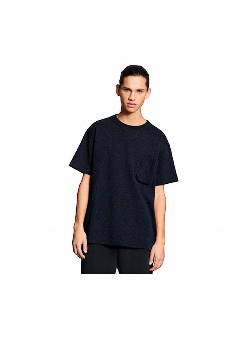 Hombre vistiendo camiseta negra The Hype Company con bolsillo 3D texturizado y corte holgado