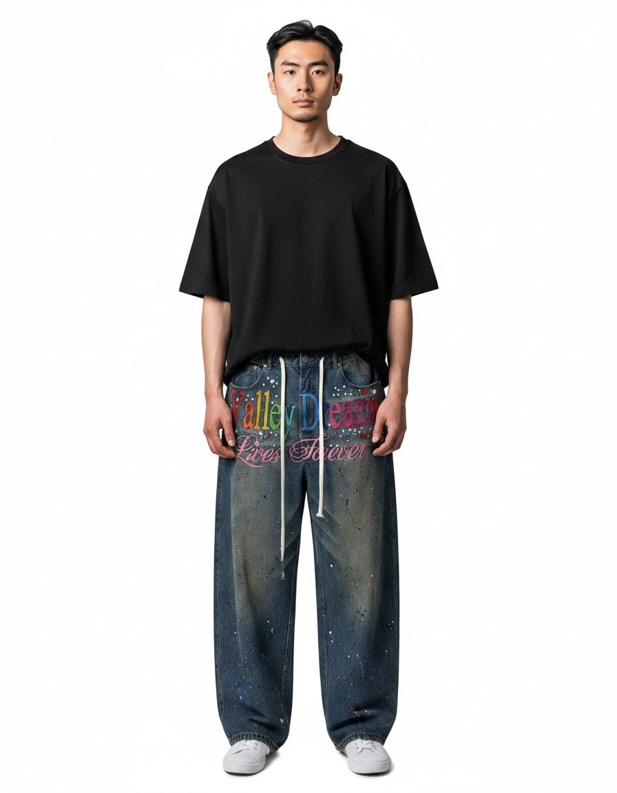 Modelo vistiendo jeans de mezclilla The Hype Company con bordados coloridos, efecto salpicado y cordones blancos.