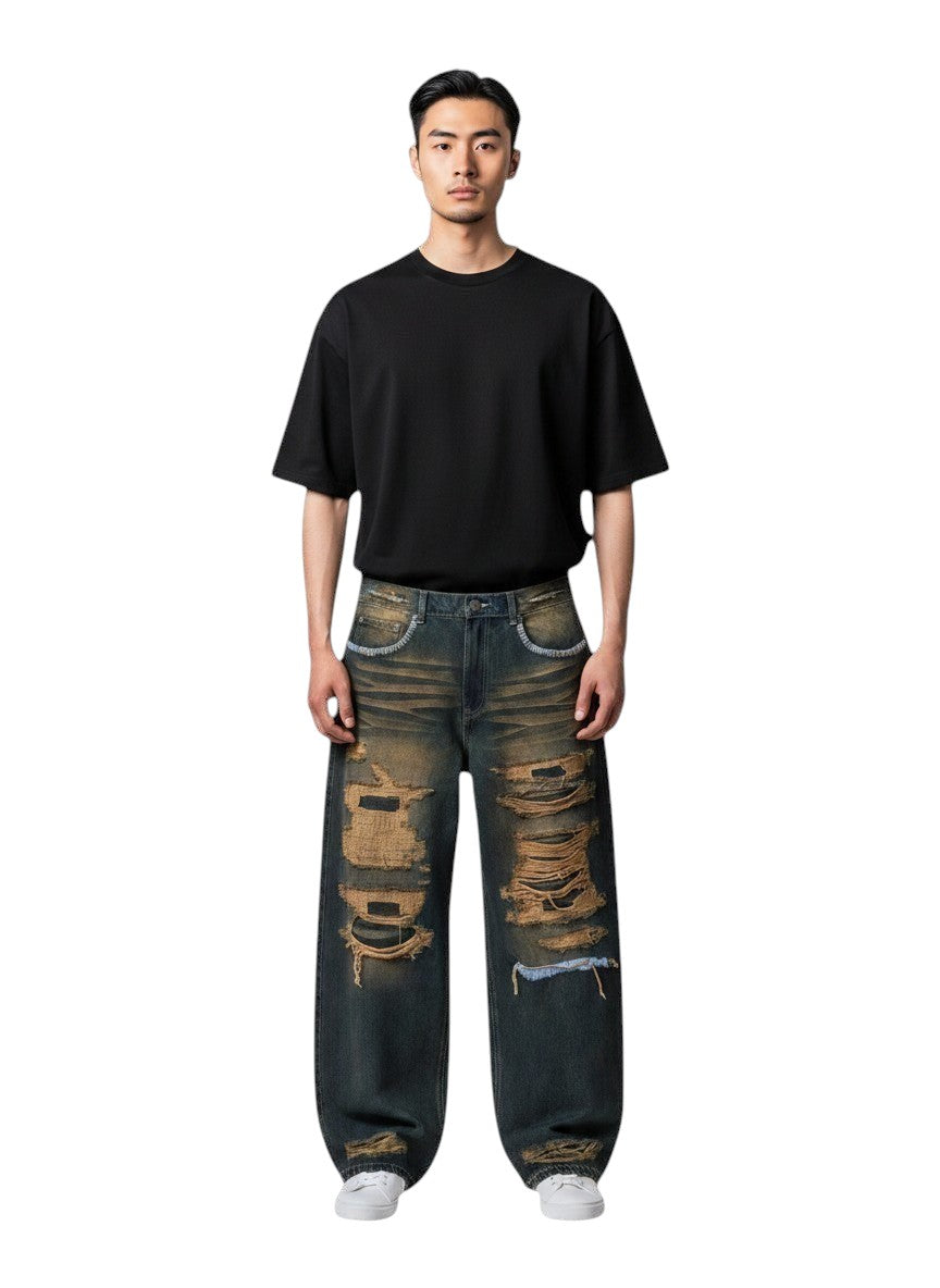 Modelo con jeans Valley Thrashed Denim de The Hype Company, corte holgado, lavado azul desgastado y roturas.
