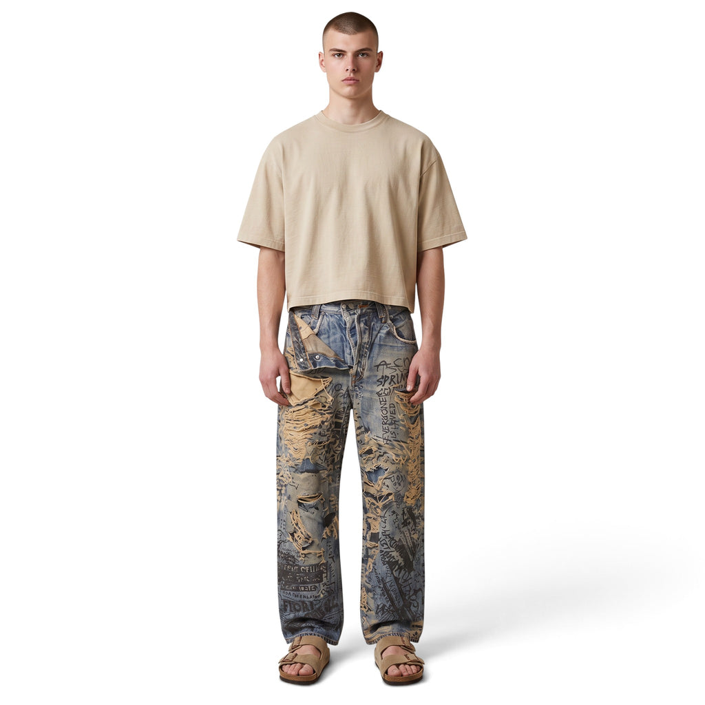 Modelo vistiendo camiseta beige y vaqueros Acne Studios con efecto trampantojo y estampado desgastado The Hype Company