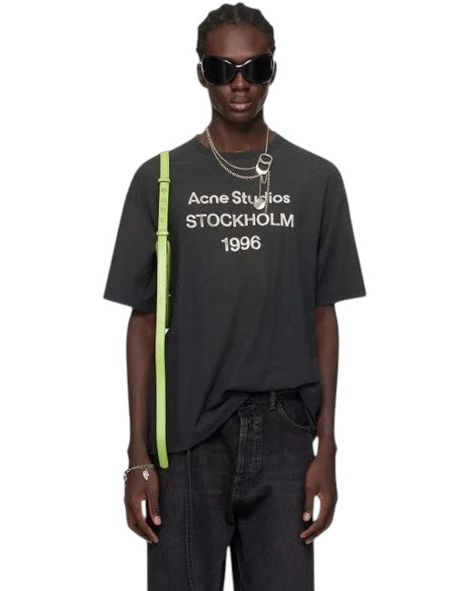 Camiseta The Hype Company Acne Studios Stockholm 1996 en negro desteñido con corte holgado y estampado frontal