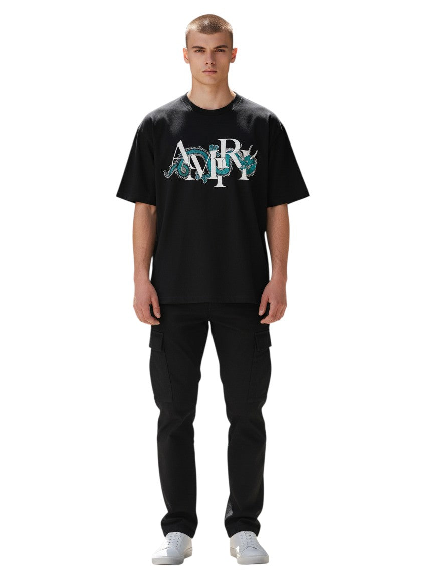 Hombre vistiendo camiseta negra AMIRI con gráfico de dragón verde y blanco de The Hype Company