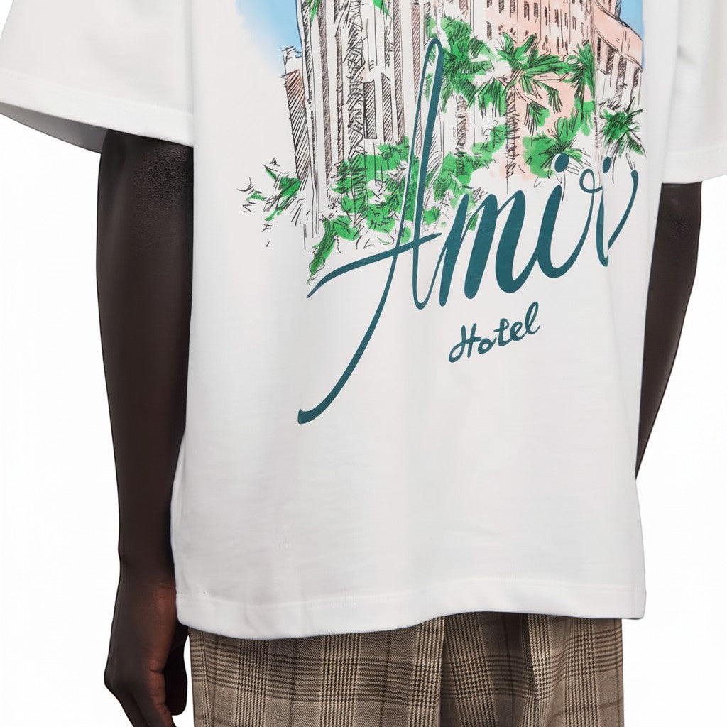 Camiseta blanca de The Hype Company con estampado gráfico de hotel y palmeras, cuello redondo y manga corta.
