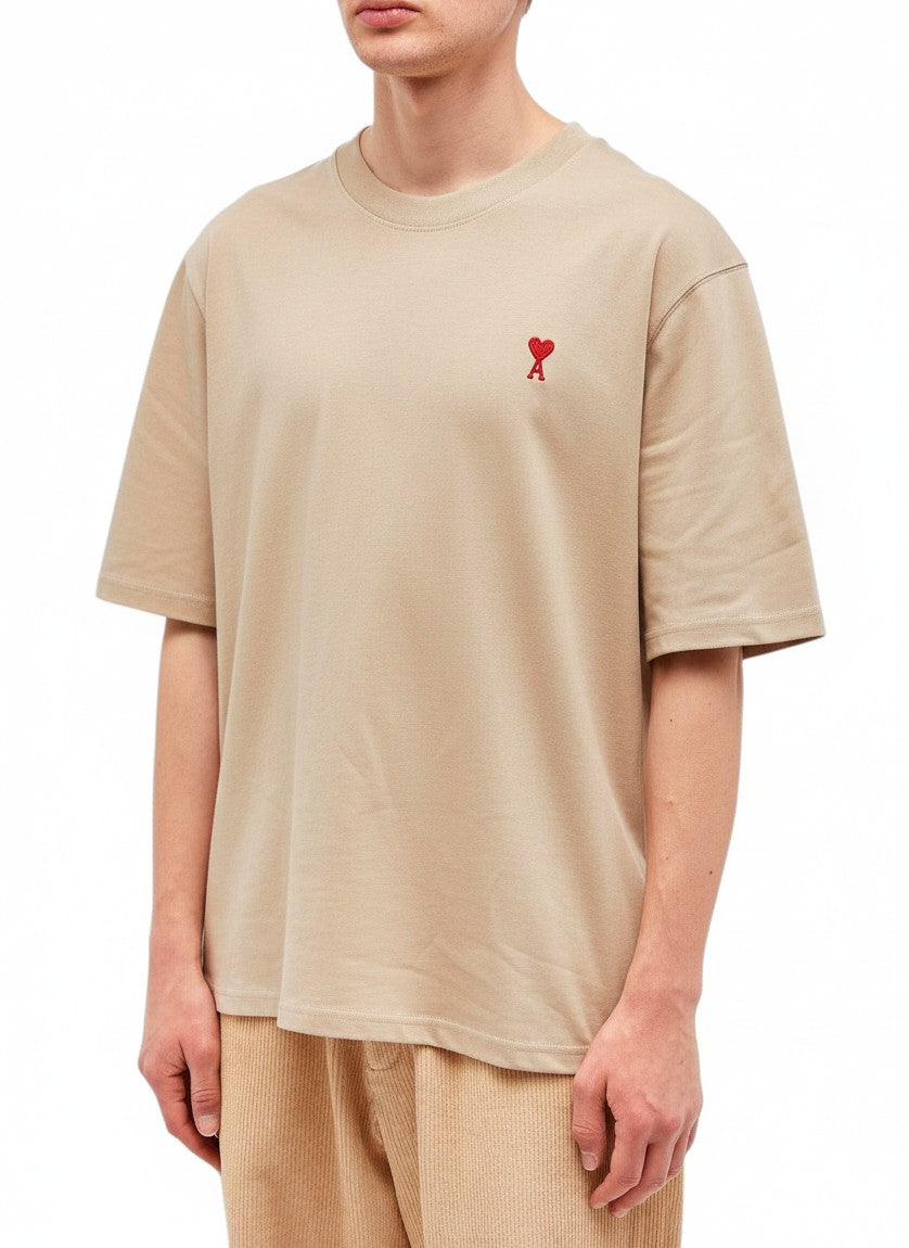 Camiseta The Hype Company color champán con logo de corazón rojo bordado en el pecho sobre modelo masculino