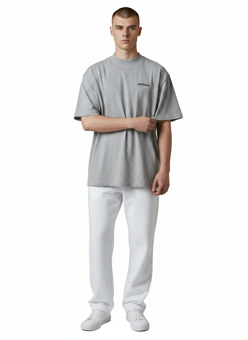 Modelo vistiendo camiseta gris de algodón con logo Off-White de The Hype Company y pantalones blancos