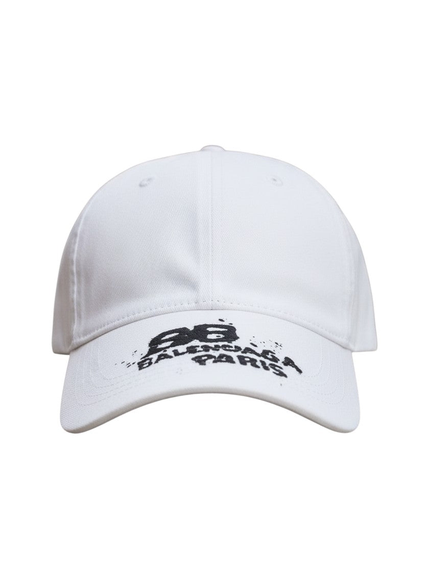 Gorra blanca The Hype Company Balenciaga BB Paris con logo bordado negro en la visera sobre fondo urbano