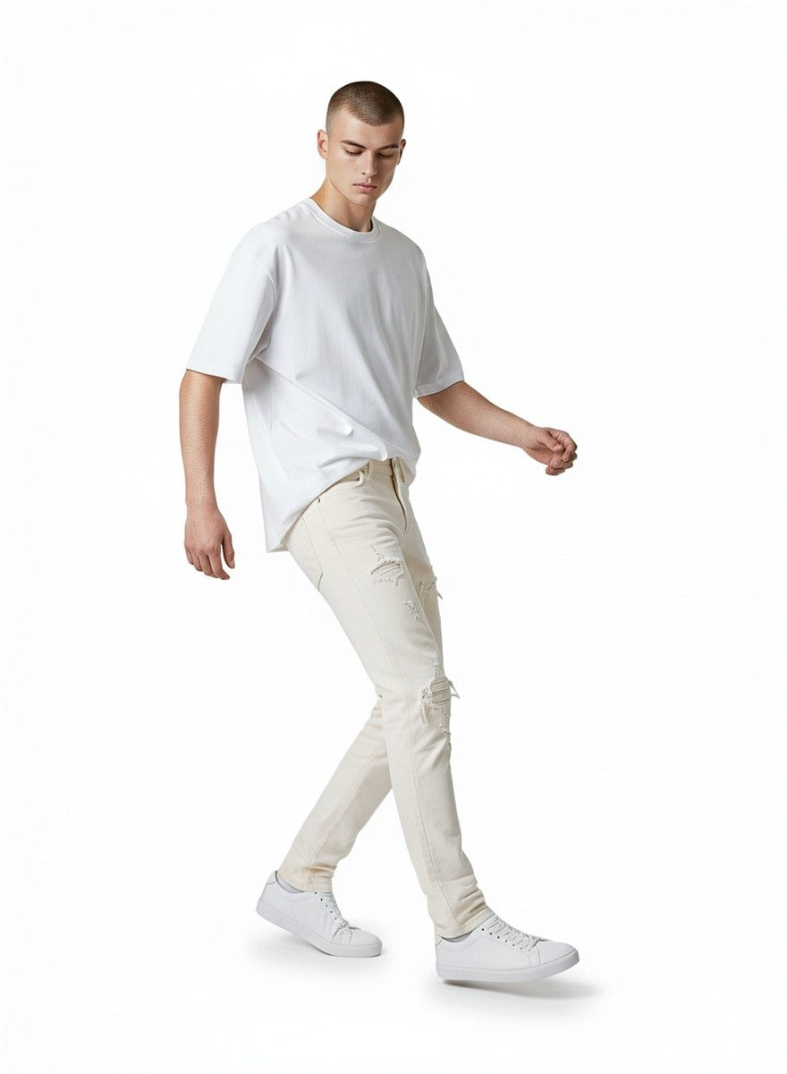 Modelo vistiendo jeans rectos desgastados color natural de The Hype Company con camiseta blanca y zapatillas
