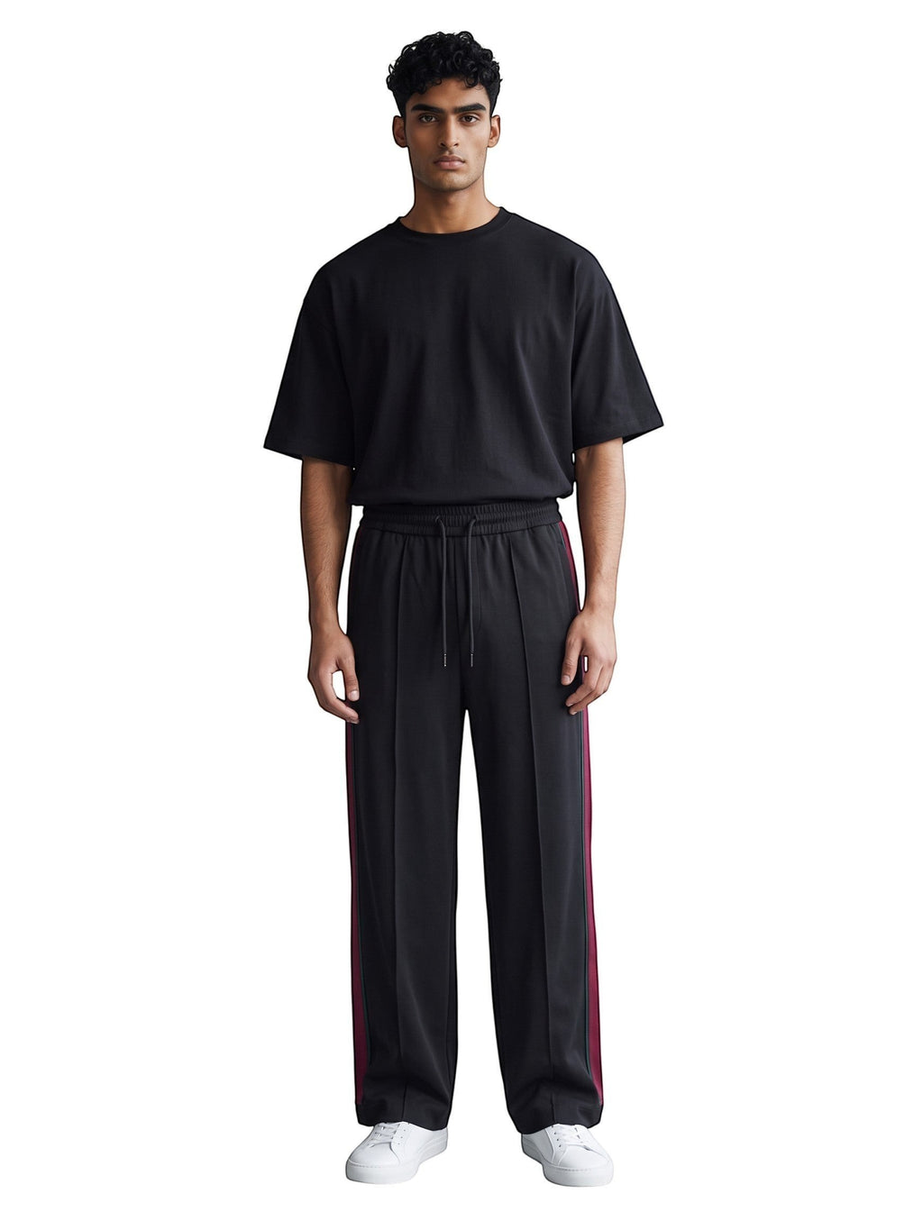Modelo vistiendo pantalones de chándal negros con rayas laterales de The Hype Company y camiseta básica negra
