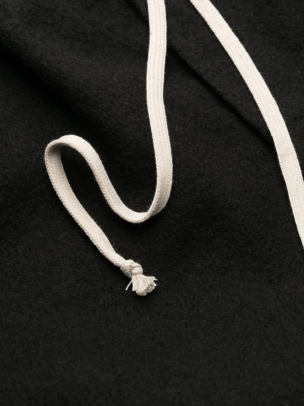 Detalle de cordón blanco en pantalones de chándal negros de The Hype Company