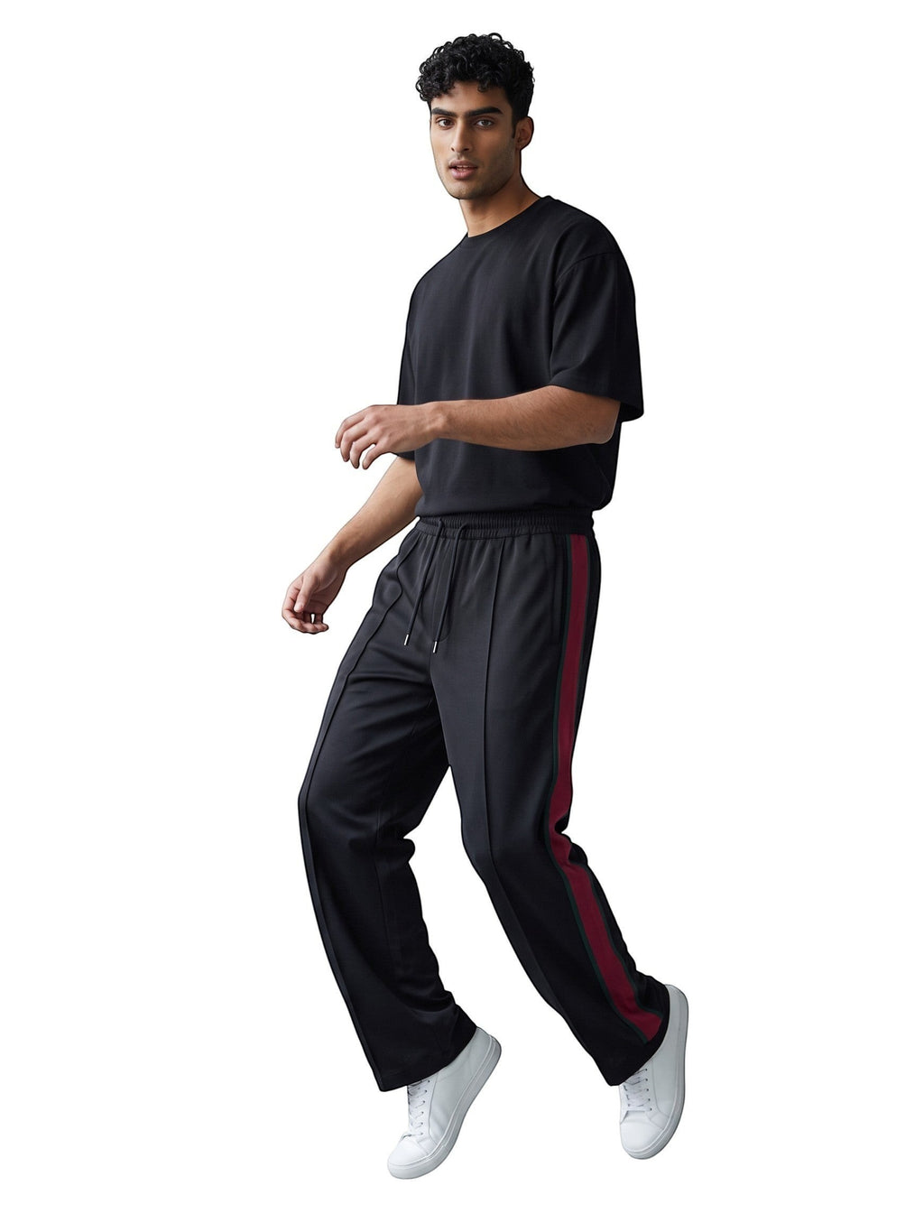 Modelo vistiendo pantalones de chándal negros con franjas laterales rojas de The Hype Company