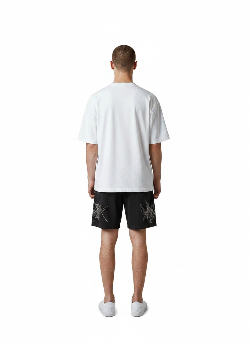 Modelo de espaldas vistiendo shorts de baño negros The Hype Company con estampado de garabatos blancos