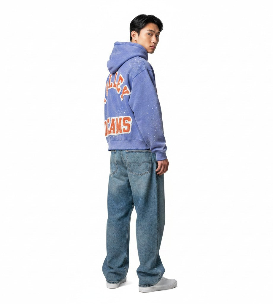 Hombre vistiendo sudadera con cremallera The Hype Company azul claro con estampado gráfico naranja y efecto salpicado