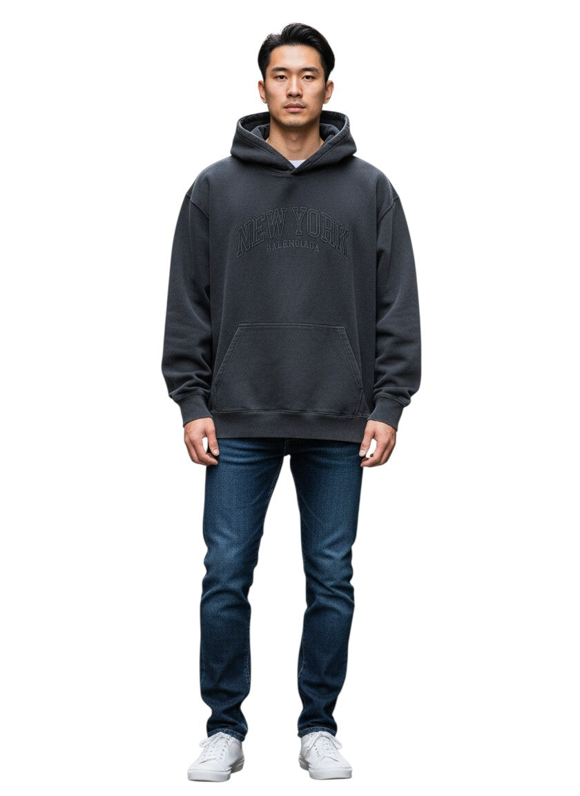 Hombre vistiendo sudadera negra Balenciaga New York de The Hype Company con jeans azules en una calle urbana