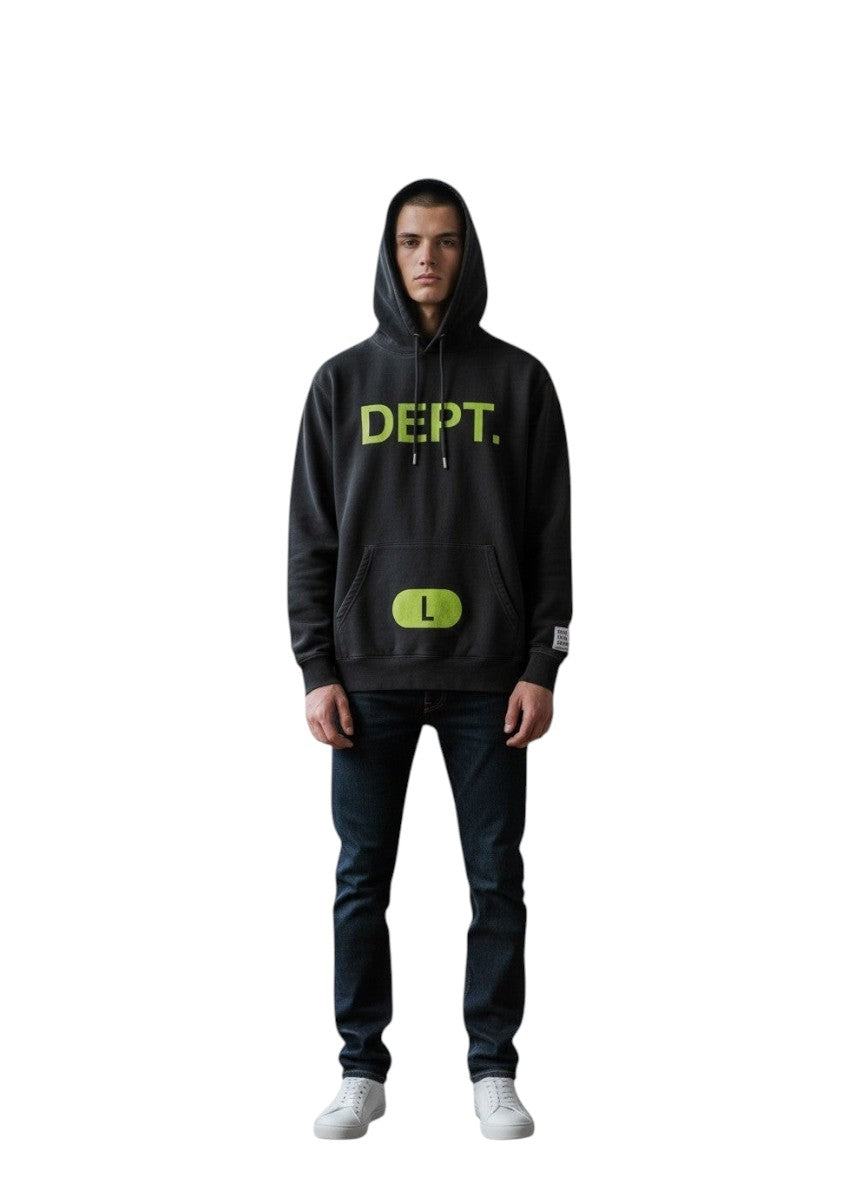 Hombre vistiendo sudadera negra con capucha y logo verde neón de The Hype Company en un estudio luminoso